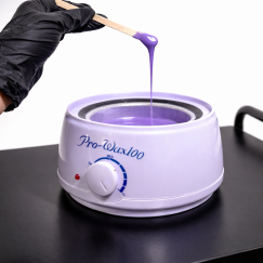 Мастер набирает воск шпателем из воскоплава